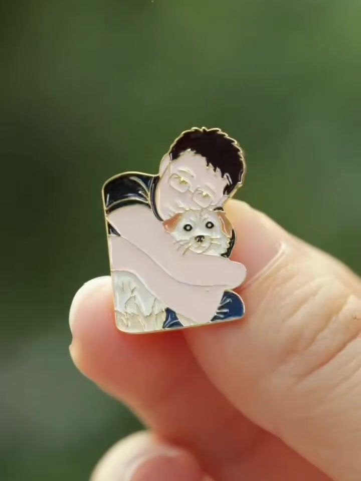 Enamel pin of a man hugging his small dog